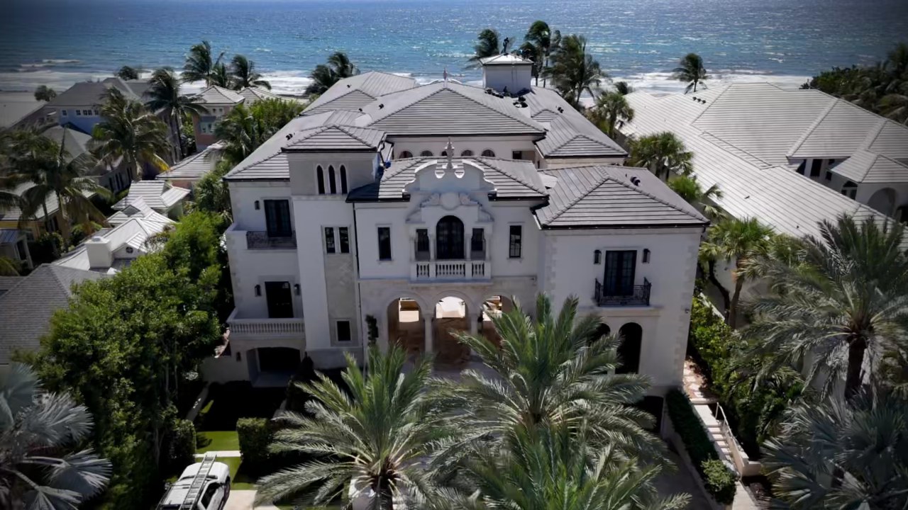 Aerial view of a Delray Beach oceanfront estate with its preserved tile roof and the Atlantic Ocean behind it