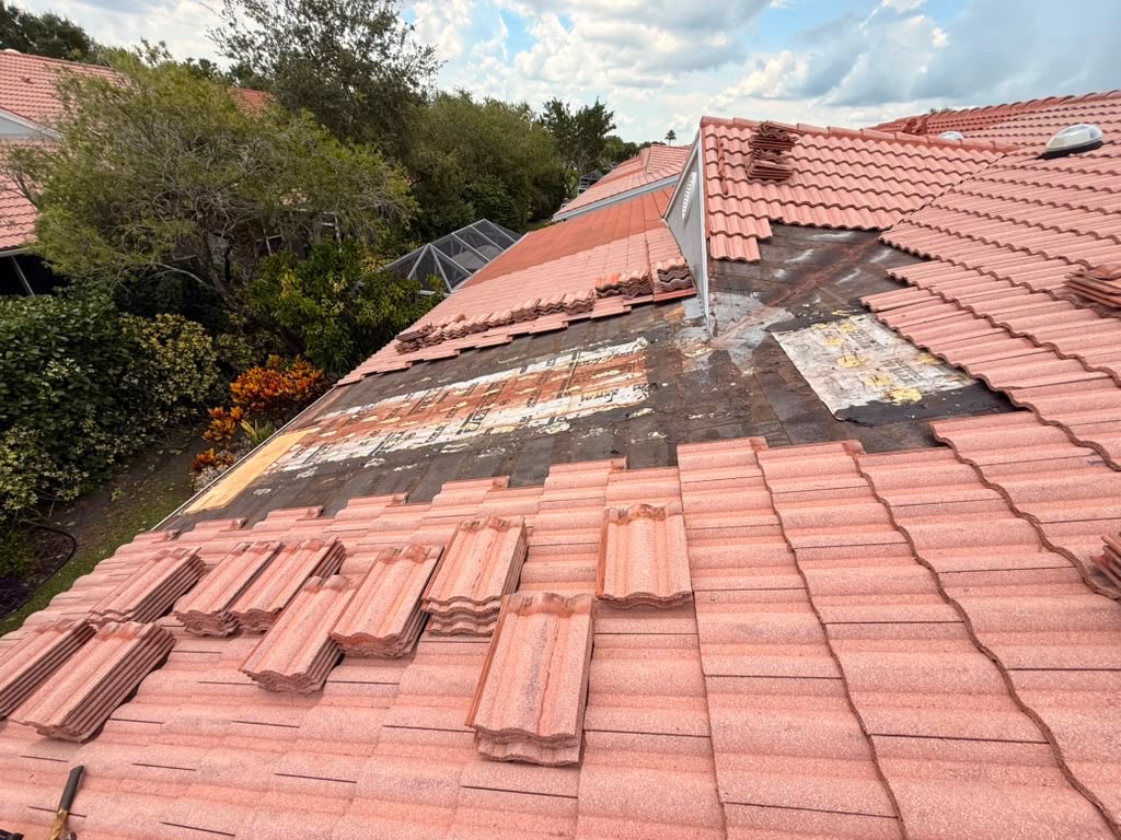 Tile roof section stripped back showing multiple previous repair patches