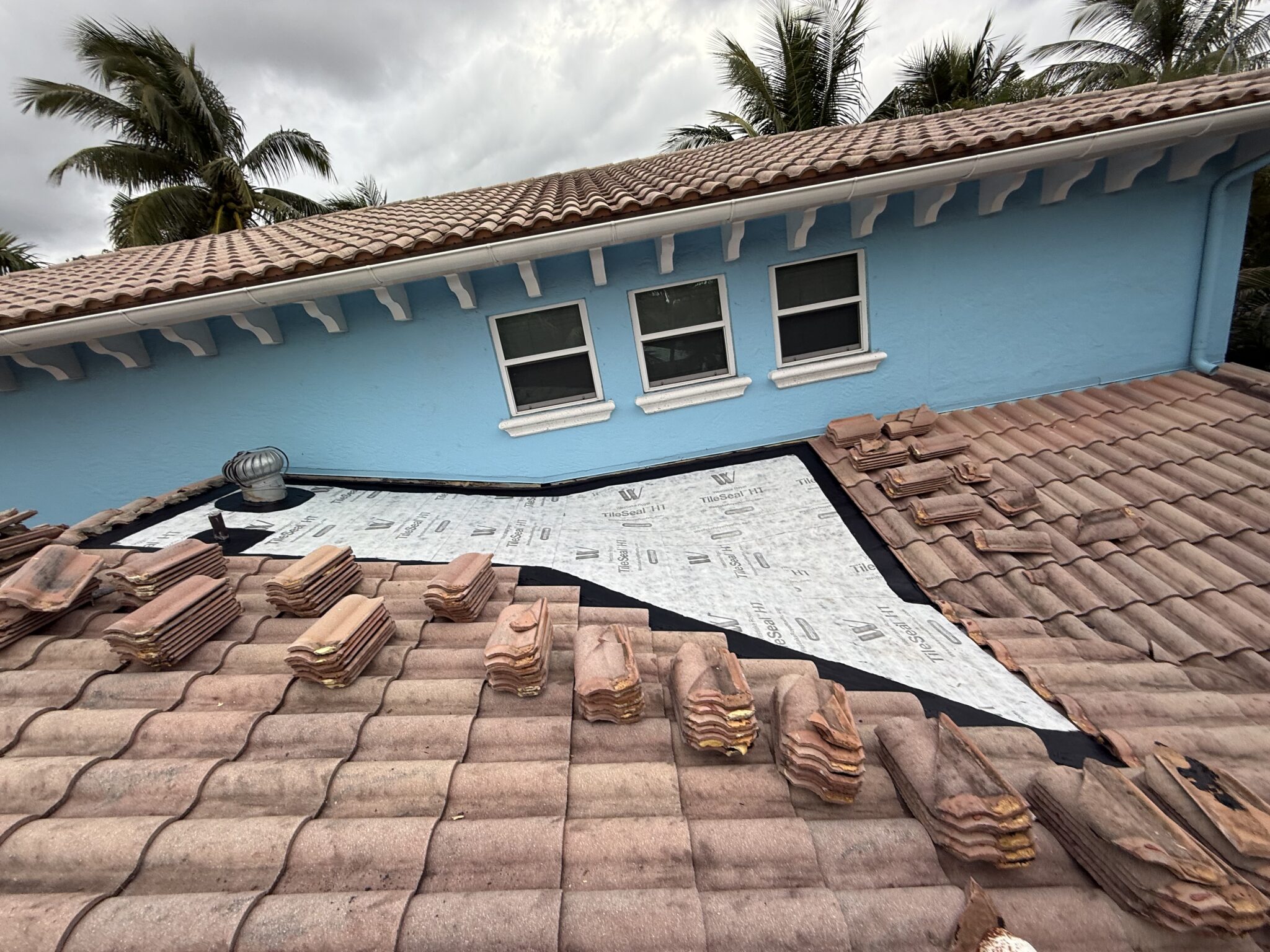 Gulf Stream tile roof section rebuilt with new high-temperature self-adhered underlayment, original tiles stacked in order for reinstallation
