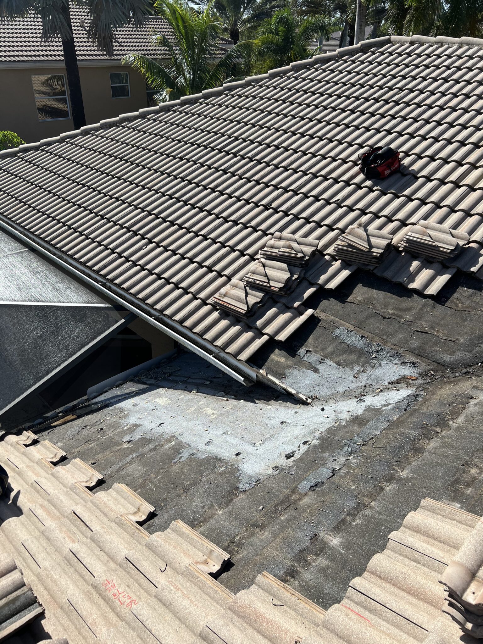 Failed tile roof repair in Greenacres where roofing tar and granules were spread over the surface
