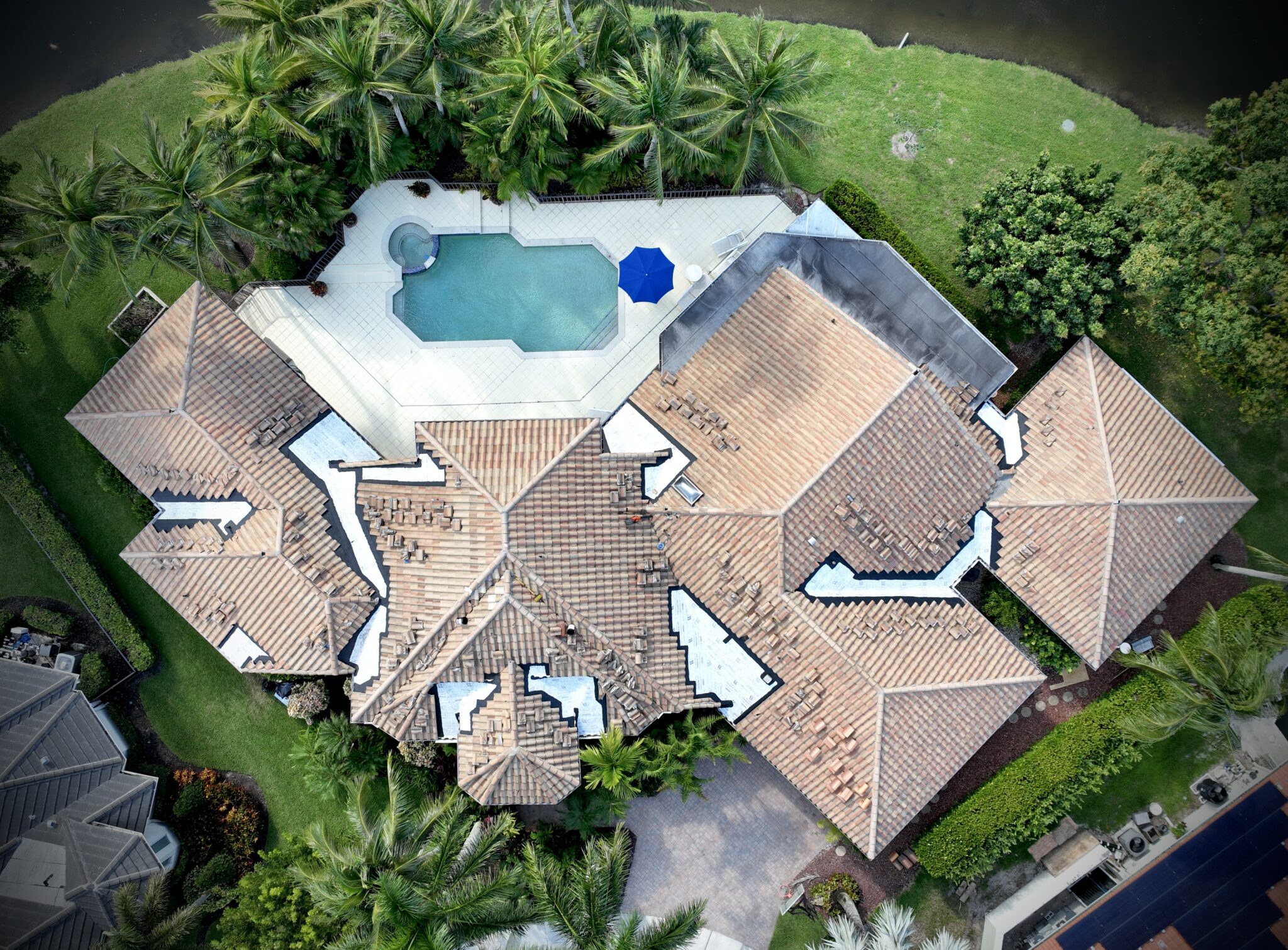 Drone view of an estate tile roof with sections opened for new underlayment