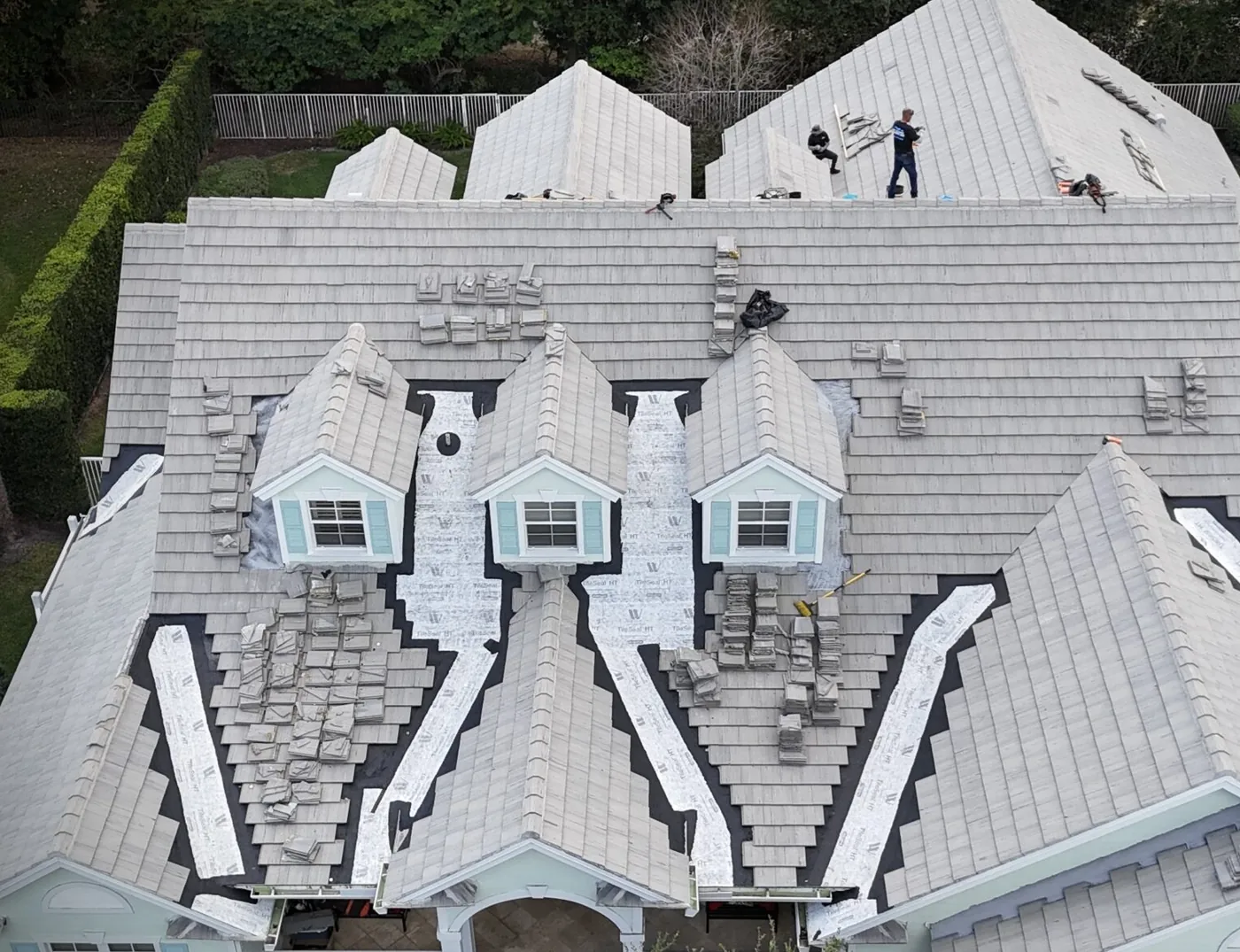 A tile roof section opened for a proper repair, with new underlayment going in and the surrounding tile preserved