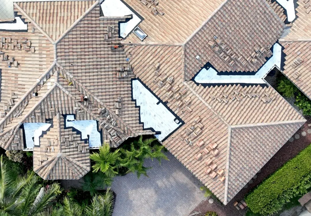 Aerial view of a Palm Beach County tile roof with targeted repair areas opened and new underlayment installed