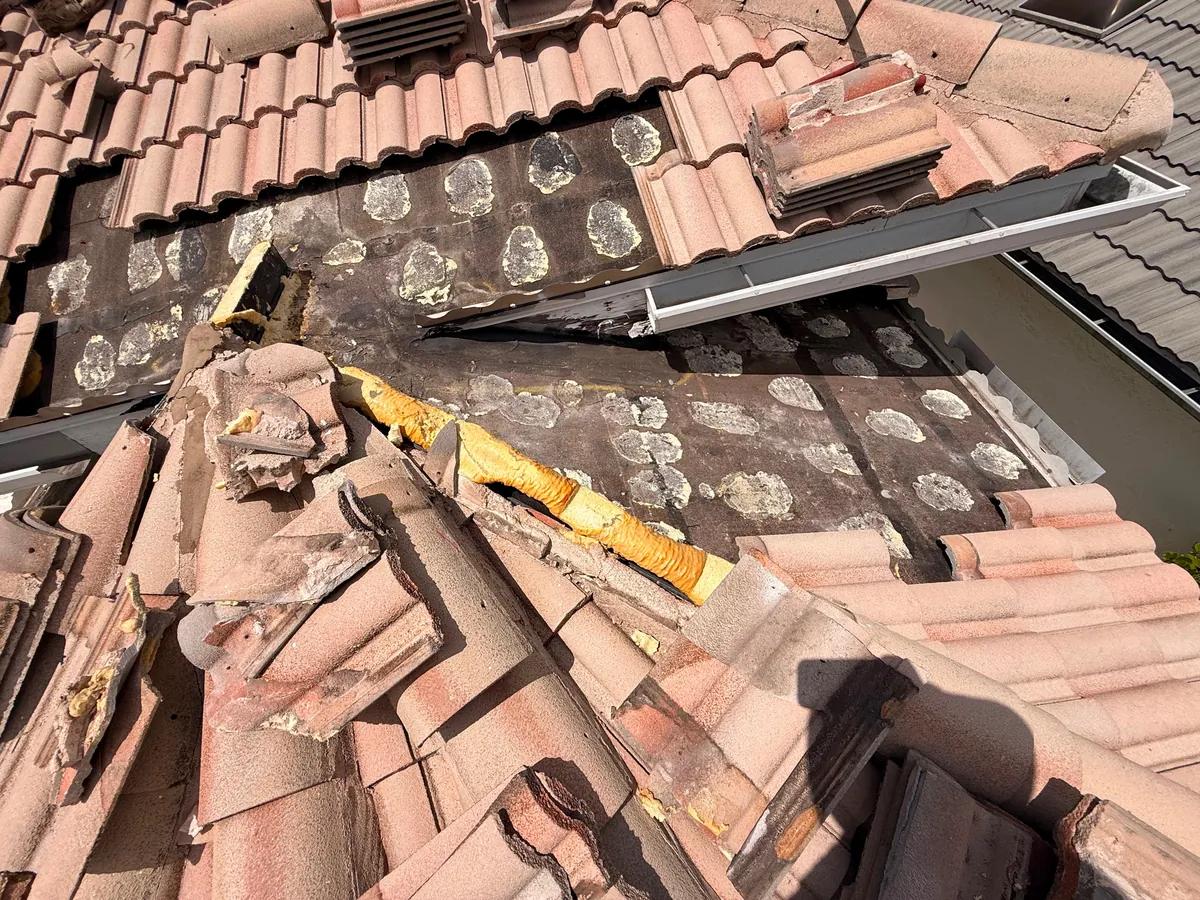 Barrel tile lifted on a Boca Raton estate roof, exposing failed foam-set underlayment