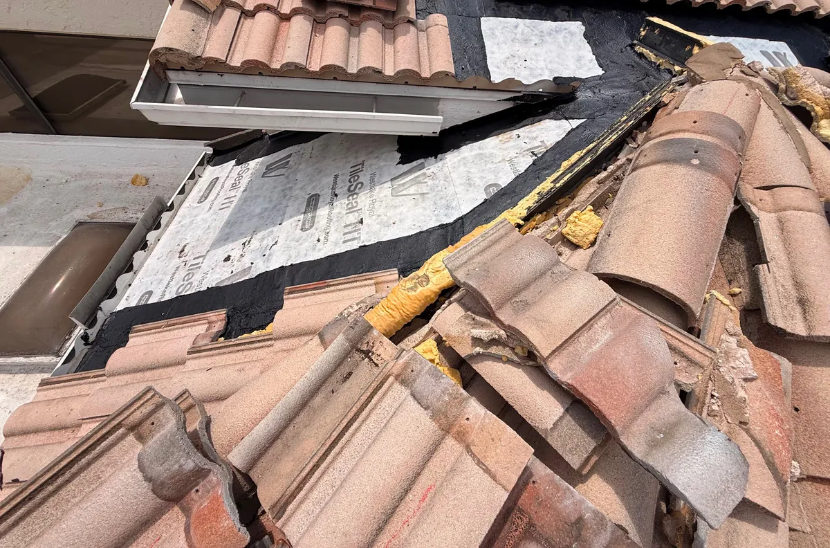 A restored roof section with new underlayment and reset tile