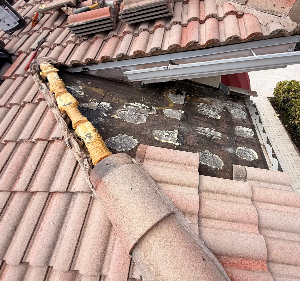 A roof section opened along a hip, old underlayment exposed