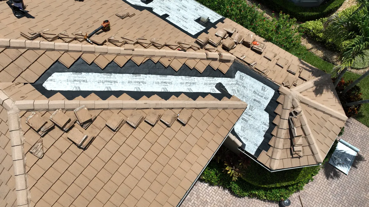 A single repair area on the tile roof with underlayment installed and tiles staged for reset