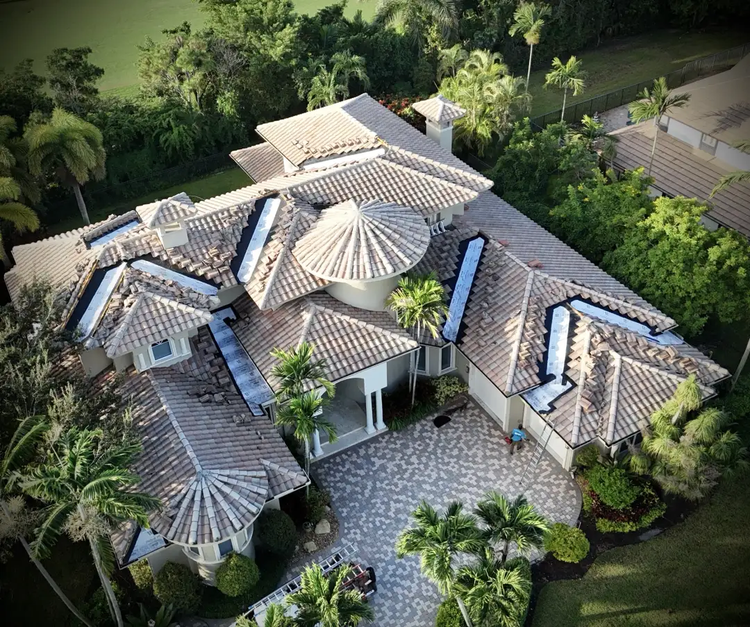 Overhead drone photo of a large tile roof with several valley sections opened down to underlayment during repair by Mike McGilvary Roofing.