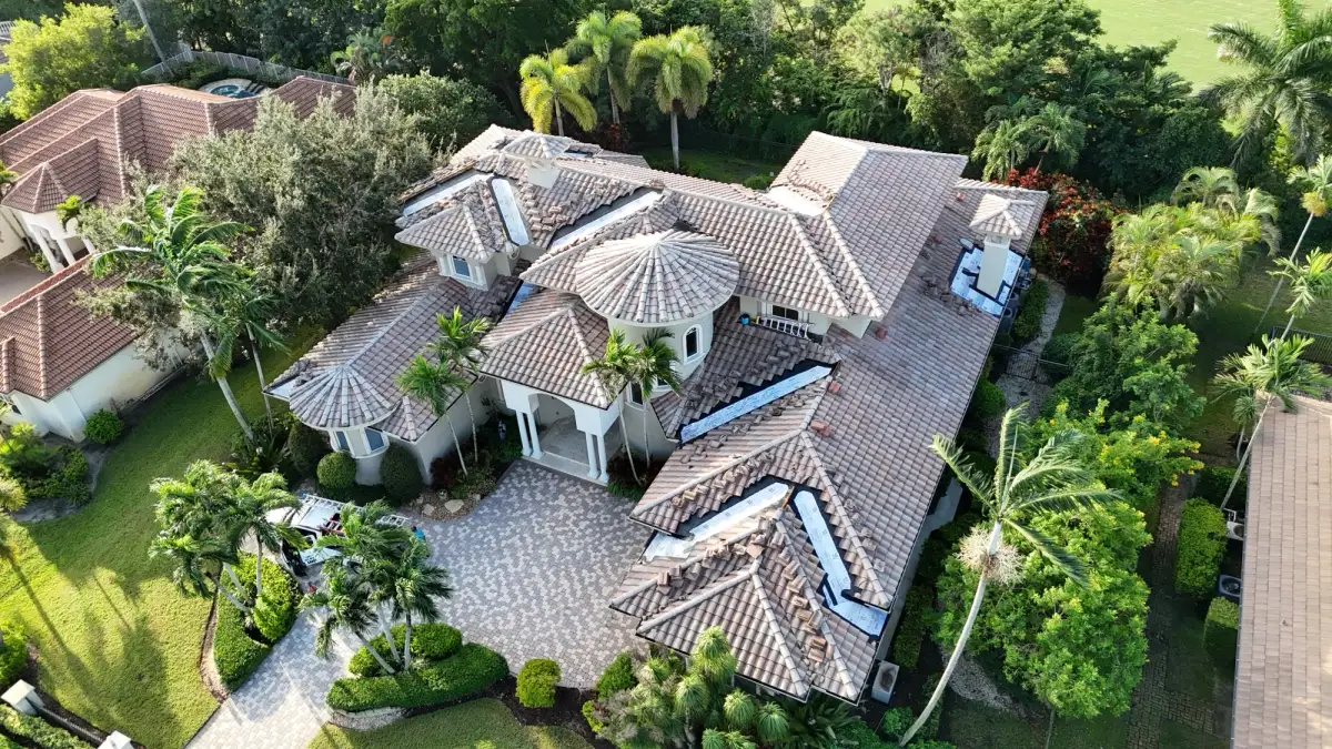 Angled drone photo of a tile roof showing multiple valley repair sections in progress.