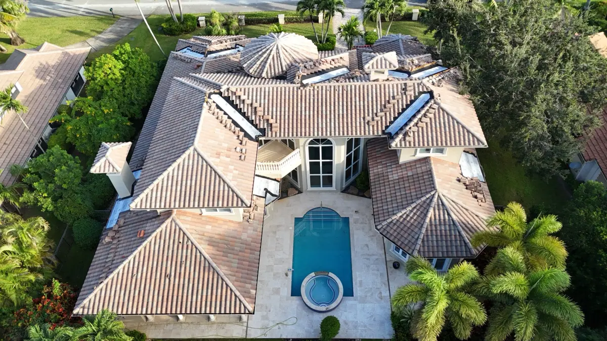 Aerial view of the rear tile roof slopes over a pool deck, with valley repair sections open.