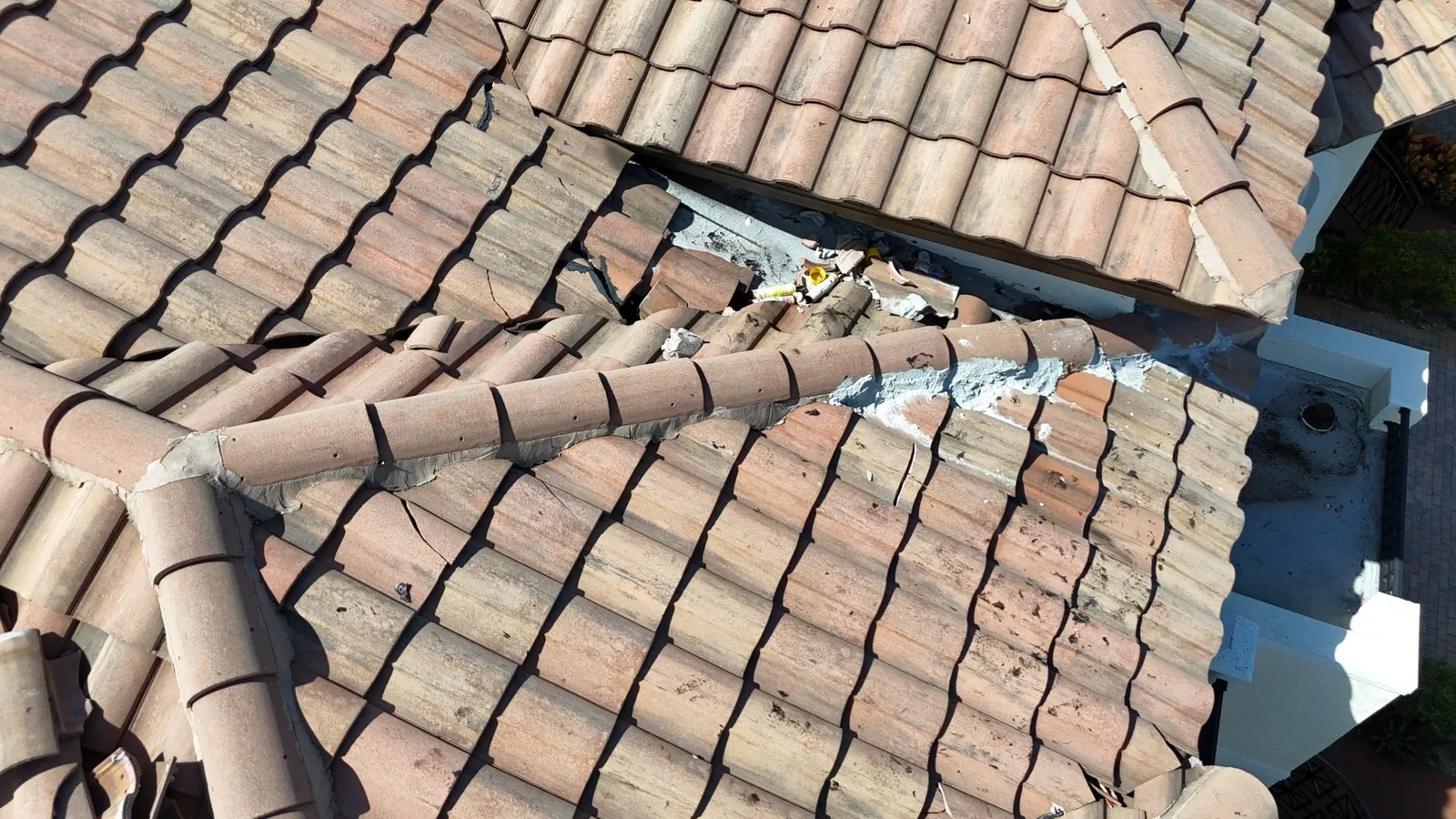 Close-up of debris and smeared mortar at a tile roof repair