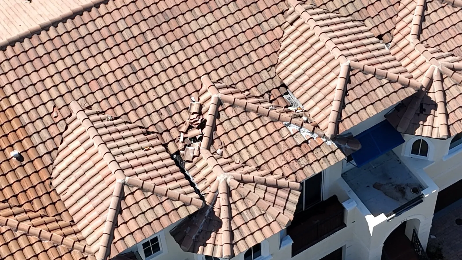 Displaced barrel tile and smeared mortar at a roof junction