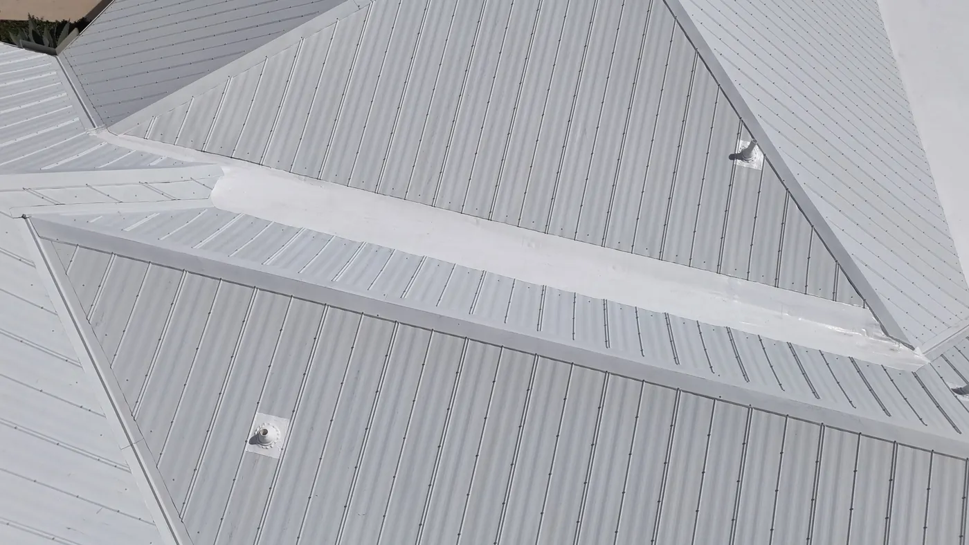 After: the same kind of transition restored and coated, the coated strip running along the base of the metal panels.