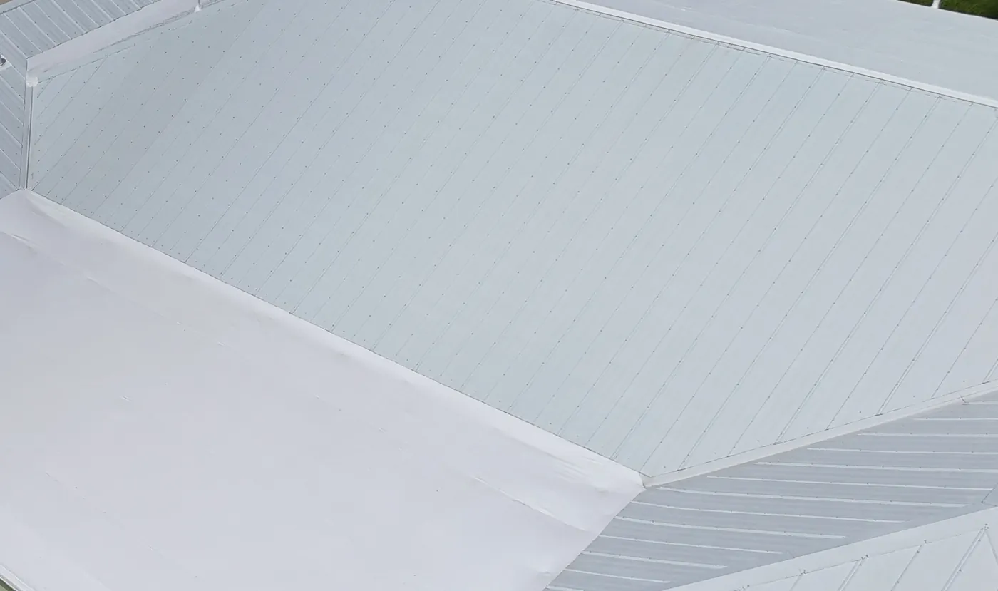 After: the rear flat section restored with a white coating, metal roof slopes on both sides.