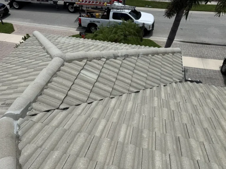 The street-side roof finished, with the tiles and ridge caps back in place and a Mike McGilvary Roofing truck on the street.