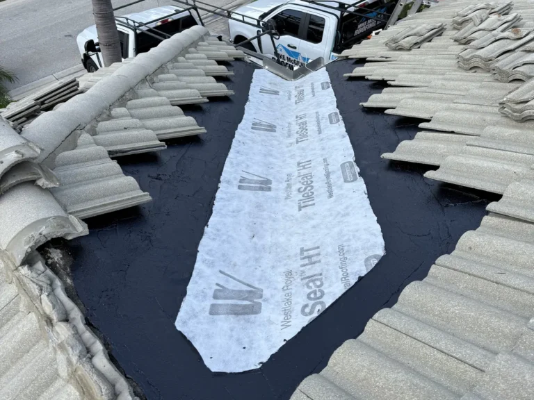 The street-side valley lined with new self-adhered underlayment, with the tiles stacked on both sides.