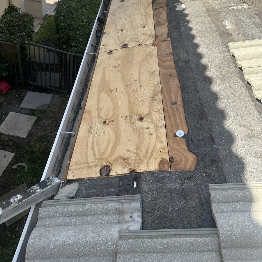 Stage 3: the same section with new plywood sheathing installed and fastened.