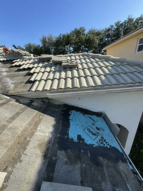 Close-up of the earlier repair at the bottom of the valley: a blue patch over dark, water-stained underlayment.
