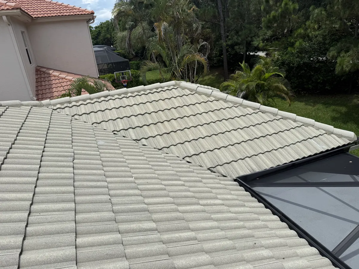 The finished concrete tile roof beside the glass pool enclosure, with no visible sign of the repair.