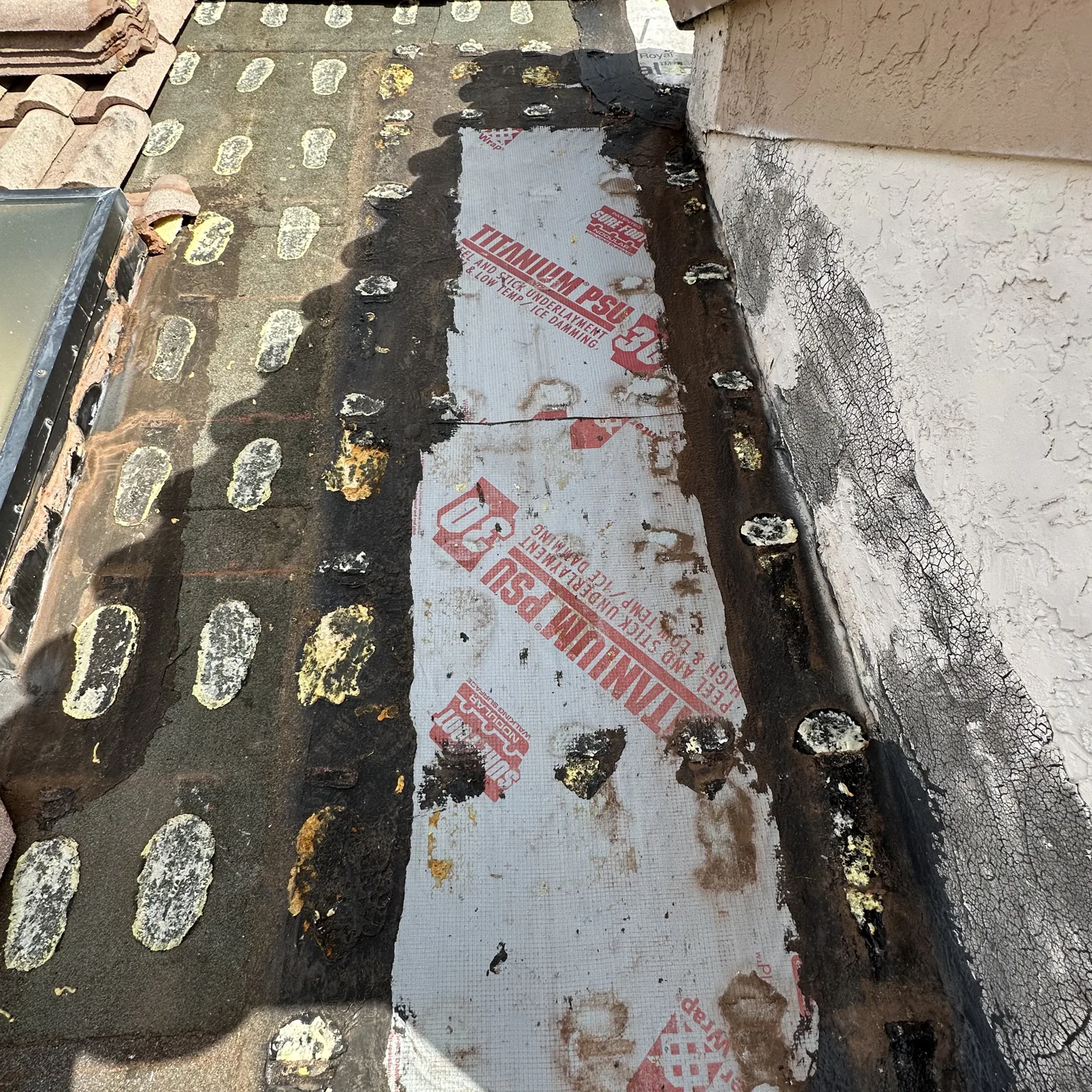 Failed underlayment and old sealant beside a skylight on a Palm Beach Shores tile roof before the section rebuild