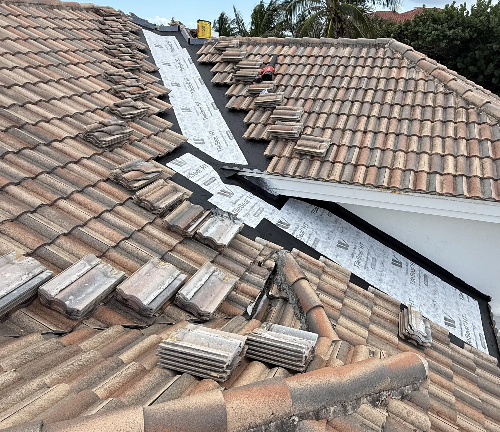 New high-temperature self-adhered underlayment installed across the rebuilt section of a Palm Beach Shores tile roof, tiles staged for reinstallation