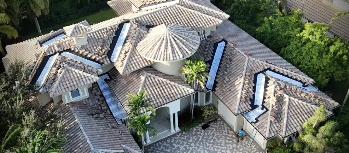 Overhead drone photo of a large tile roof with several valley sections opened down to underlayment during repair by Mike McGilvary Roofing.
