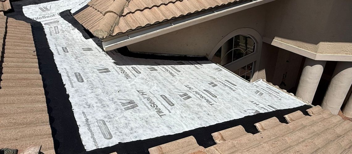 Tile removed and new underlayment installed along a tile roof section