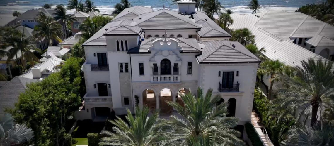 Aerial view of a Delray Beach oceanfront estate with its preserved tile roof and the Atlantic Ocean behind it