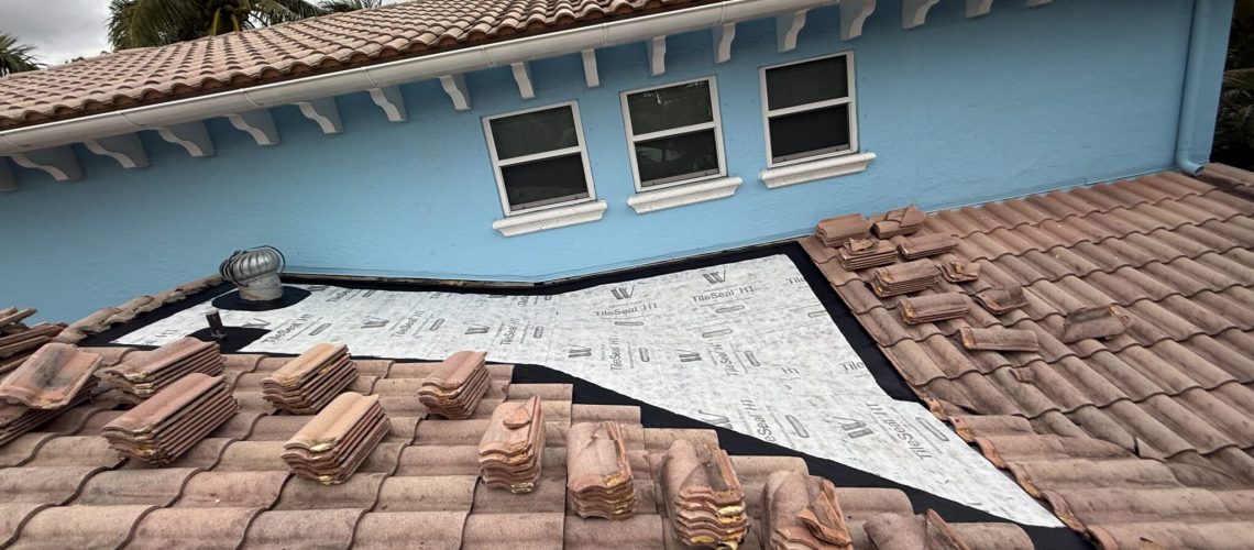 A tile roof section rebuilt with new underlayment where the roof meets a wall