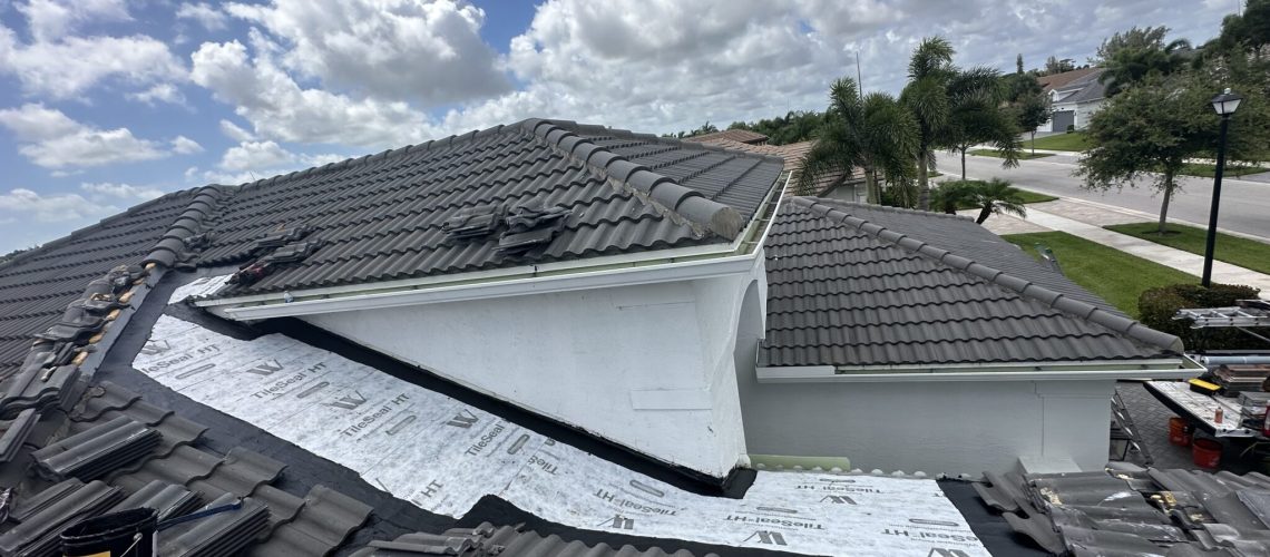 A concrete tile roof with a section opened for new underlayment